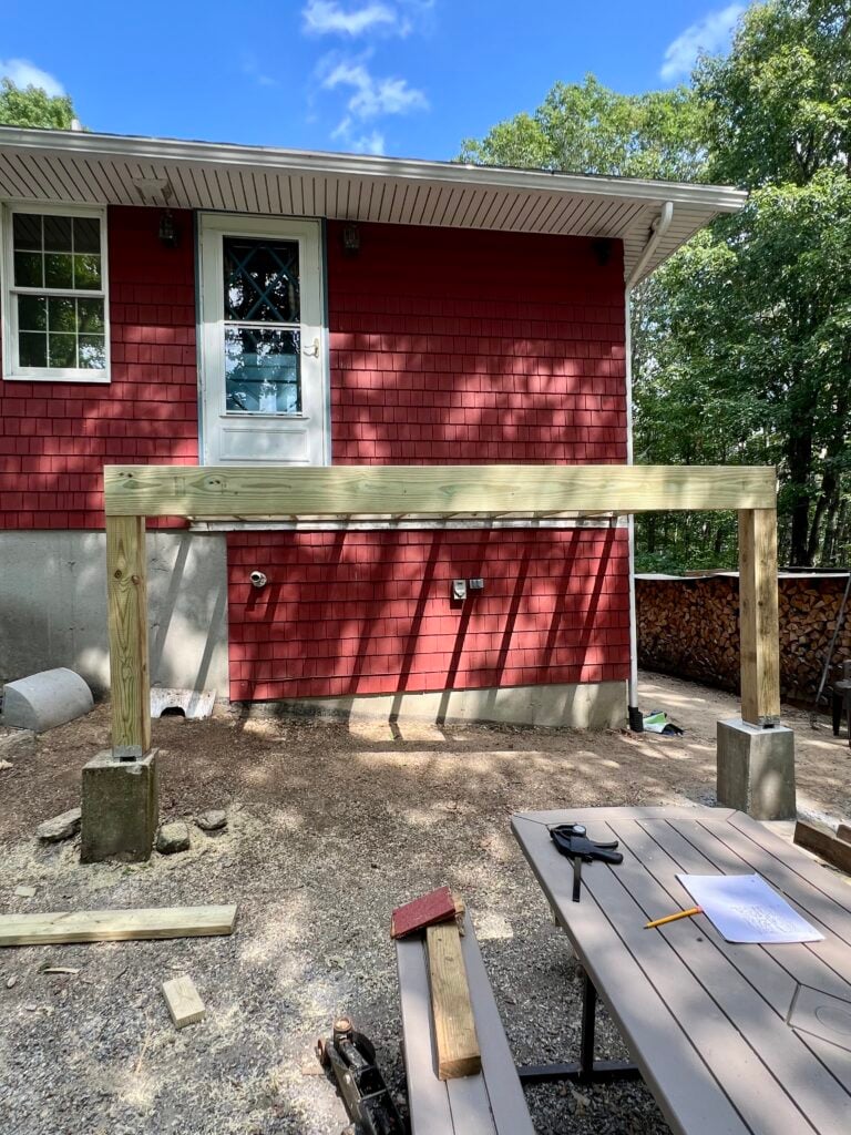 DIY deck framing attached to house exterior before installing Trex composite decking