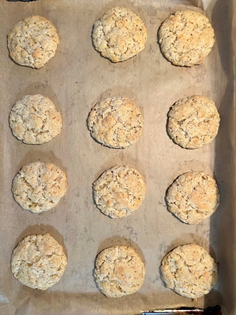 Freshly baked cookies cooling on a parchment-lined baking sheet