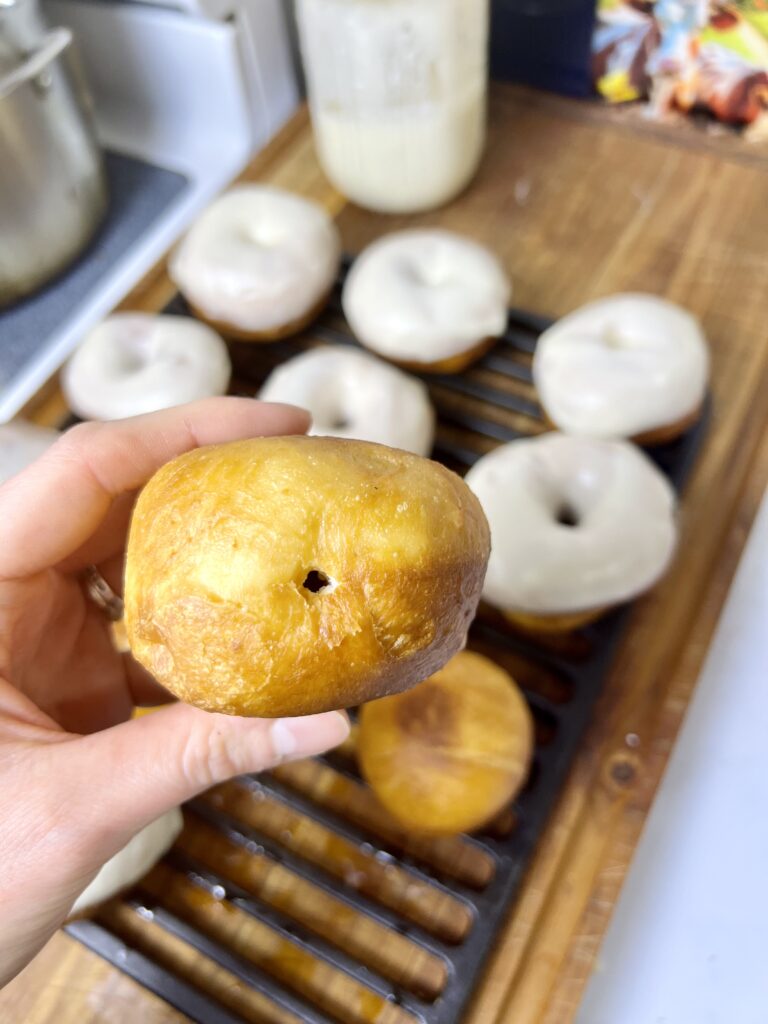 A donut with a hole in the side, ready for filling.