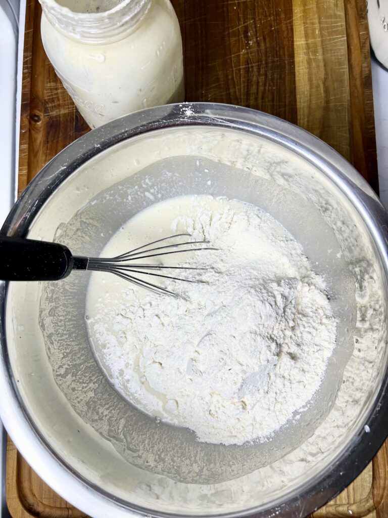 Mixing in the dry ingredients in a stainless steel bowl with a whisk.