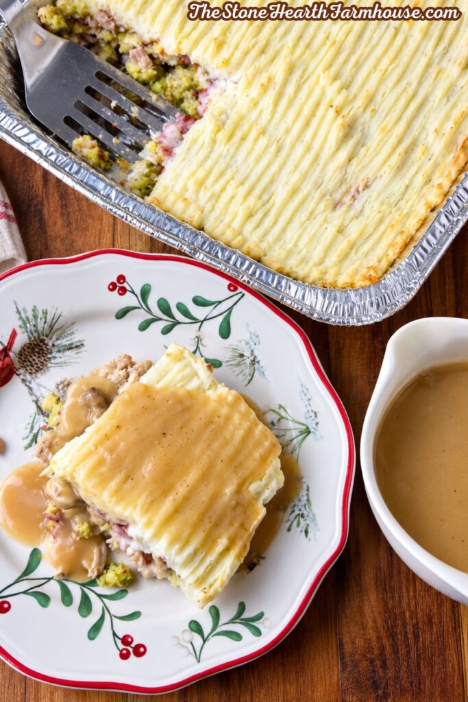 Thanksgiving casserole with leftover turkey, stuffing, cranberry sauce, and mashed potatoes topped with gravy