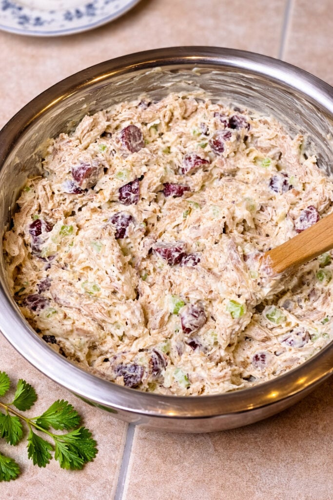 Large bowl of creamy chicken salad with red grapes, celery, and tender shredded chicken for a crowd recipe