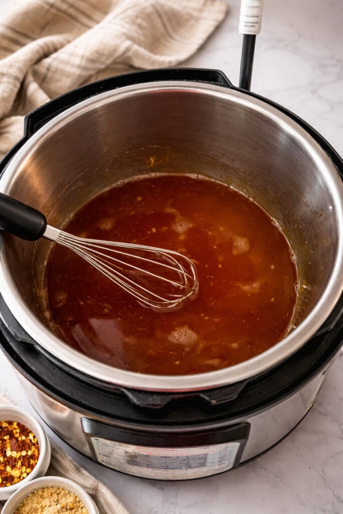 Huli Huli sauce ingredients whisked in Instant Pot including soy sauce pineapple juice and brown sugar