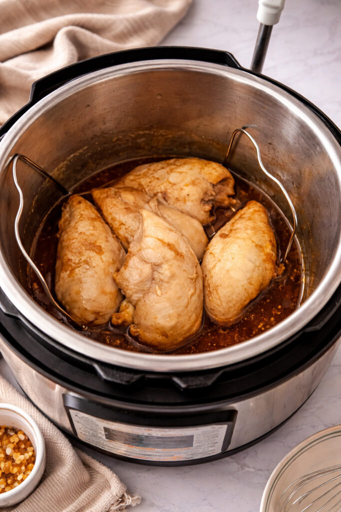 Cooked chicken breasts in Instant Pot on trivet with Huli Huli sauce after pressure cooking