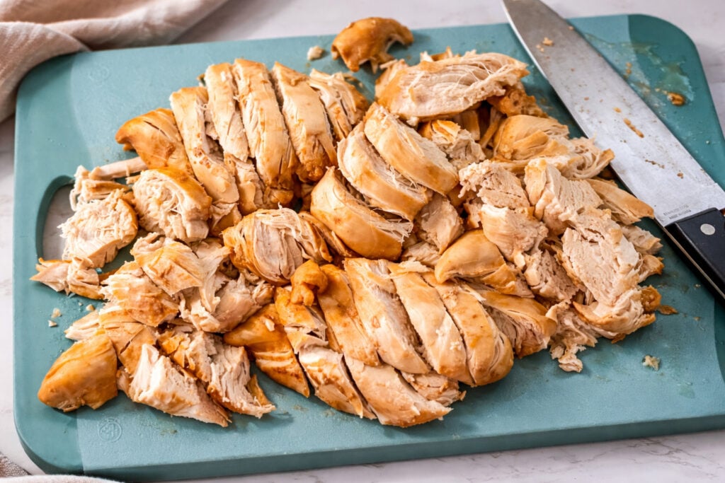 Sliced cooked chicken breast on cutting board for Huli Huli chicken Instant Pot recipe preparation