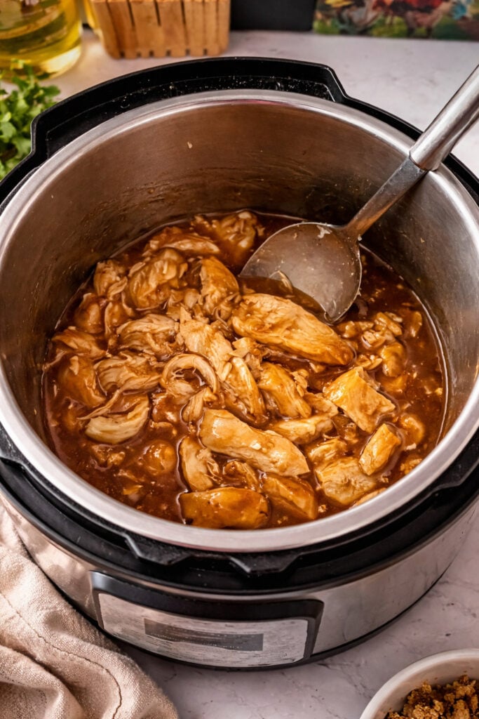 Huli Huli chicken in Instant Pot with shredded chicken simmering in sweet and savory pineapple soy sauce