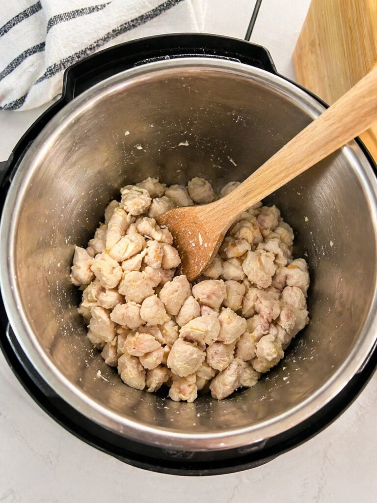Cooked diced chicken in Instant Pot for creamy chicken broccoli pasta recipe
