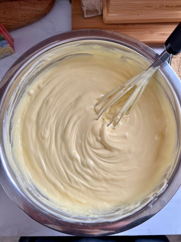 Thick and creamy vanilla pudding mixture in a mixing bowl for easy 4th of July vanilla dirt cups recipe, showing smooth fluffy texture