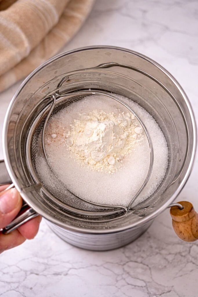 Sifting sugar and cornstarch for homemade vanilla pudding, step-by-step process for smooth, lump-free pudding recipe