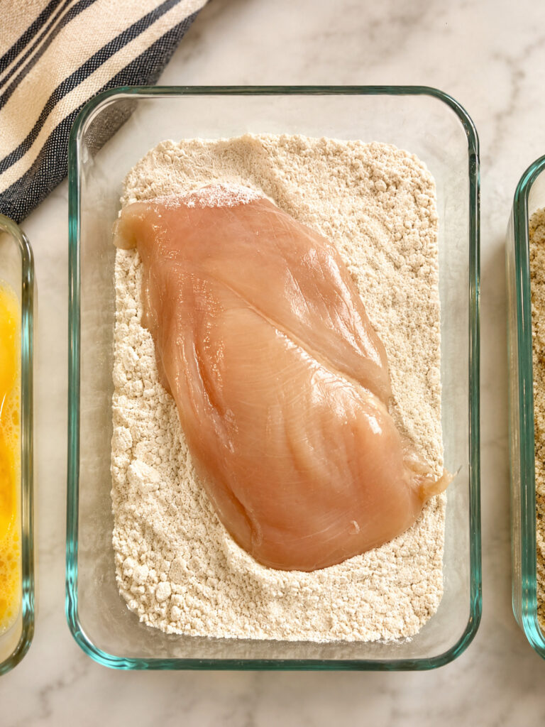 applebees lemon chicken recipe step showing chicken breast dredged in seasoned flour for crispy coating