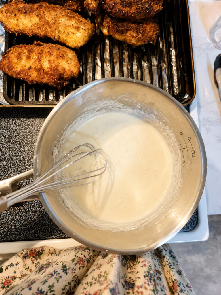 creamy lemon garlic parmesan sauce being whisked in saucepan