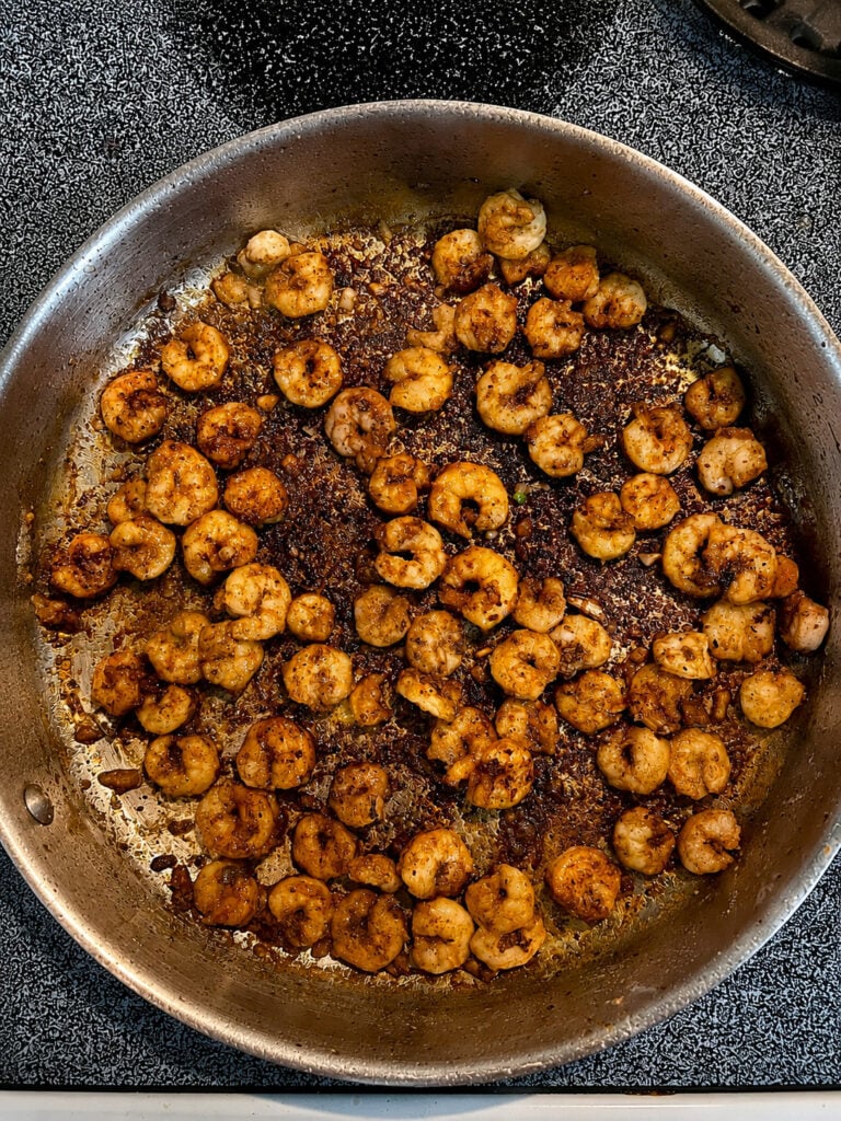 Golden browned shrimp cooked with garlic and seasoning for a creamy steak and shrimp recipe.