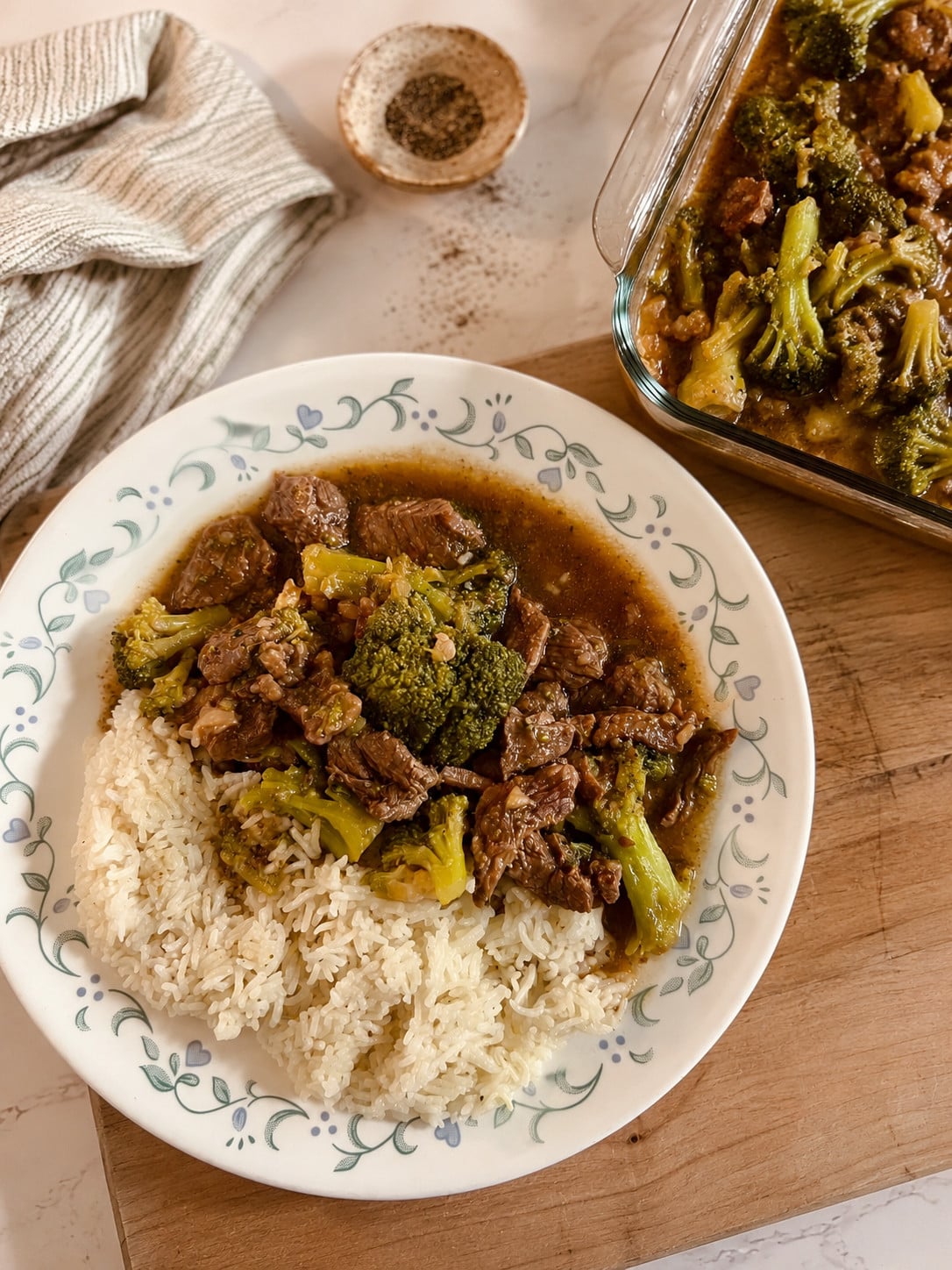 Instant Pot beef and broccoli served over white rice on a vintage floral plate with homemade savory sauce and tender beef for an easy Chinese takeout inspired dinner.