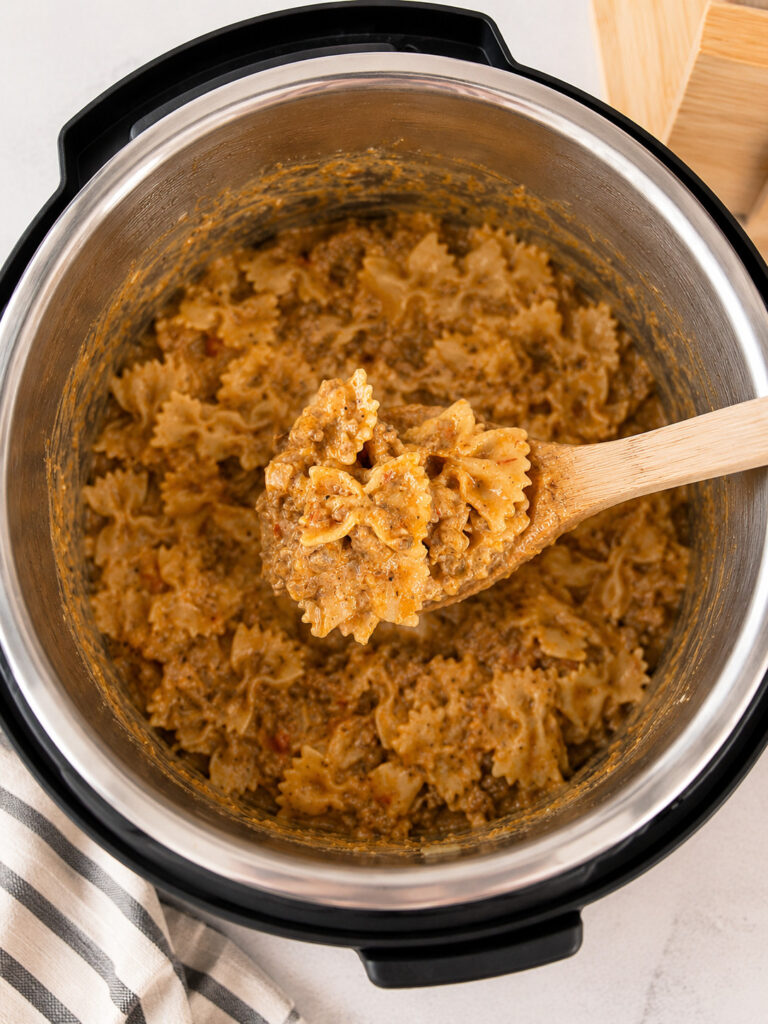 Spoonful of cheesy lasagna casserole with farfalle pasta and beef lifted from the Instant Pot