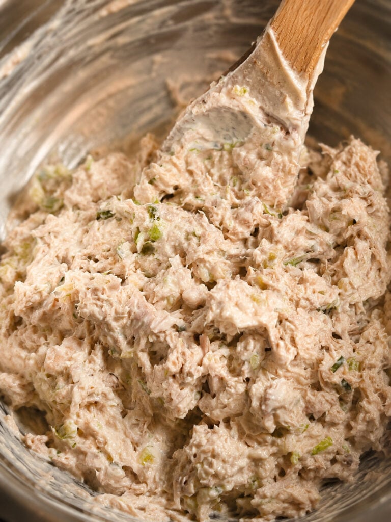 Creamy homemade Subway tuna salad mixture in a mixing bowl with chopped celery and seasonings for an easy copycat tuna sandwich recipe.