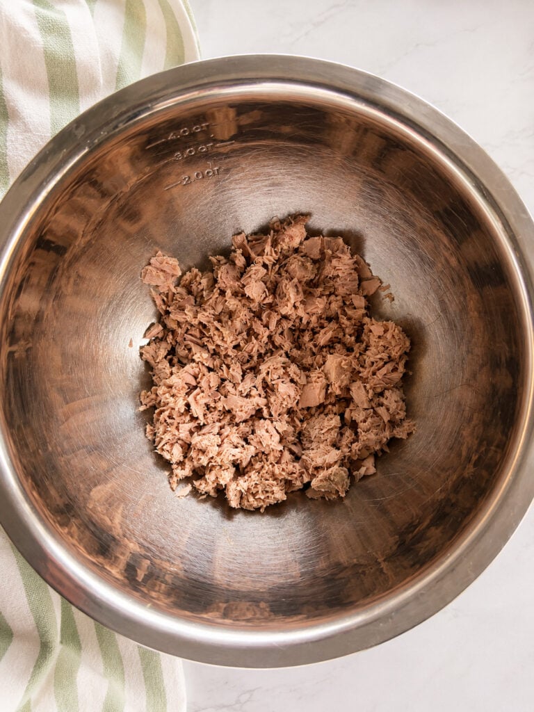 Drained canned tuna in a stainless steel mixing bowl for making creamy Subway tuna salad sandwich filling at home.