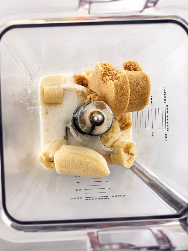 Ripe bananas, heavy cream, and brown sugar added to a blender for making homemade 3 ingredient banana ice cream. Simple ingredients ready to be blended into a creamy ice cream base.