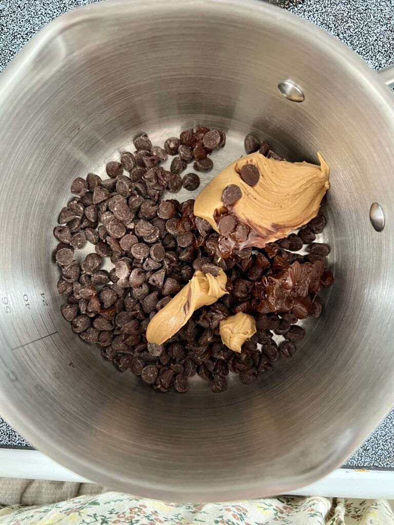Chocolate chips and creamy peanut butter in a saucepan before being mixed together for chocolate cereal bars.