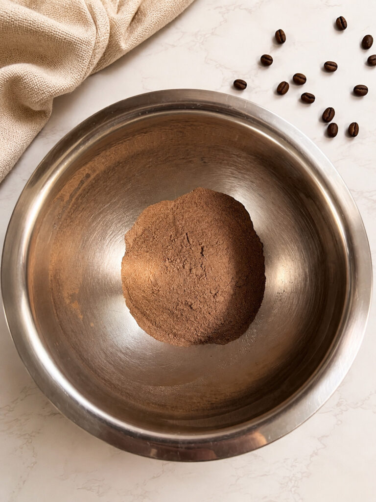 Chocolate instant pudding mix in a stainless steel mixing bowl ready to be combined with cold coffee for homemade coffee popsicles.