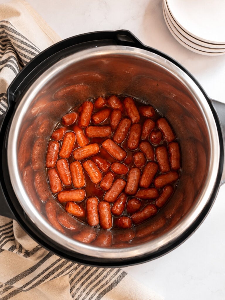 Cooked BBQ Little Smokies in the Instant Pot surrounded by sweet and tangy barbecue sauce, viewed from above.