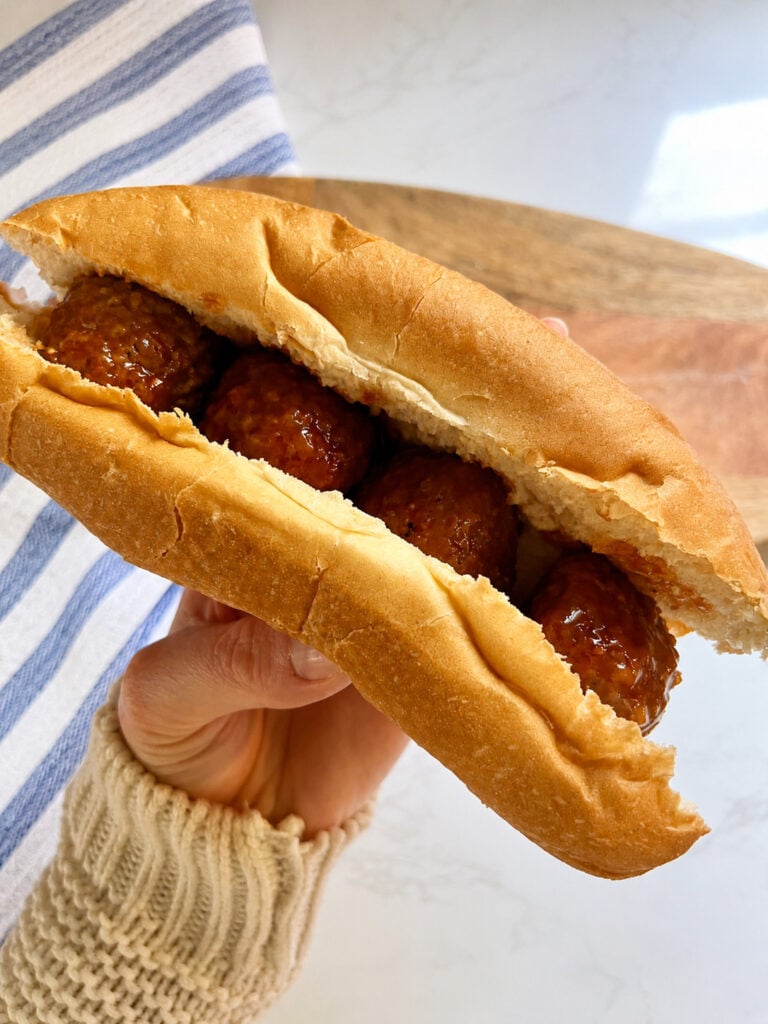 Homemade meatball sub on a soft hoagie roll filled with saucy slow-cooked meatballs and melted mozzarella cheese.