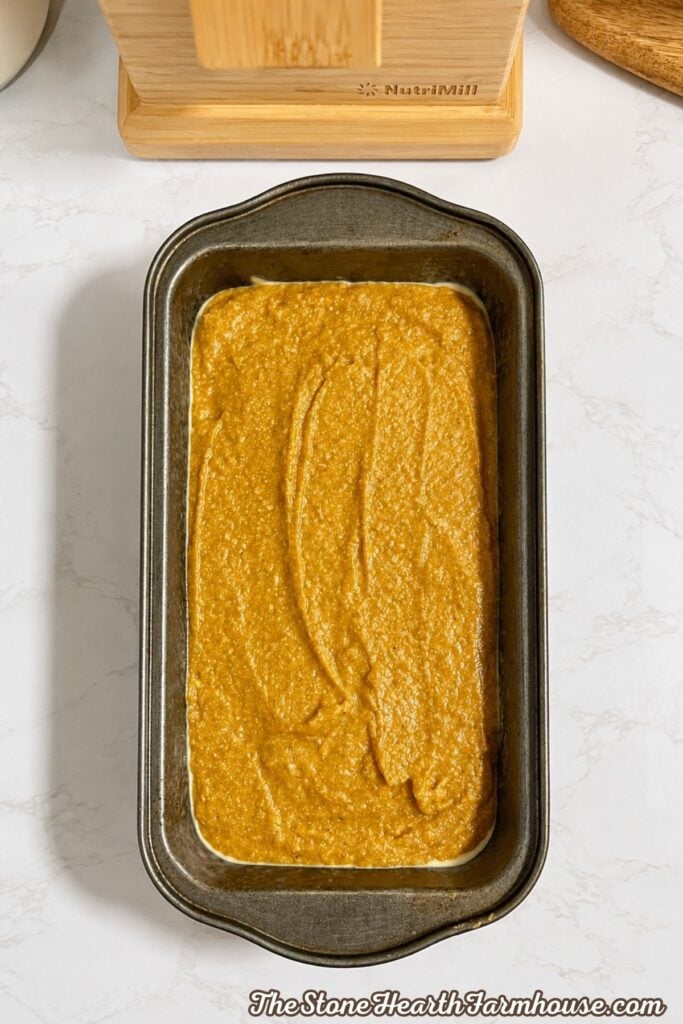Fresh milled pumpkin bread batter spread evenly in a prepared loaf pan