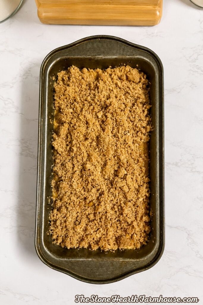 Brown sugar cinnamon streusel sprinkled over fresh milled pumpkin bread batter