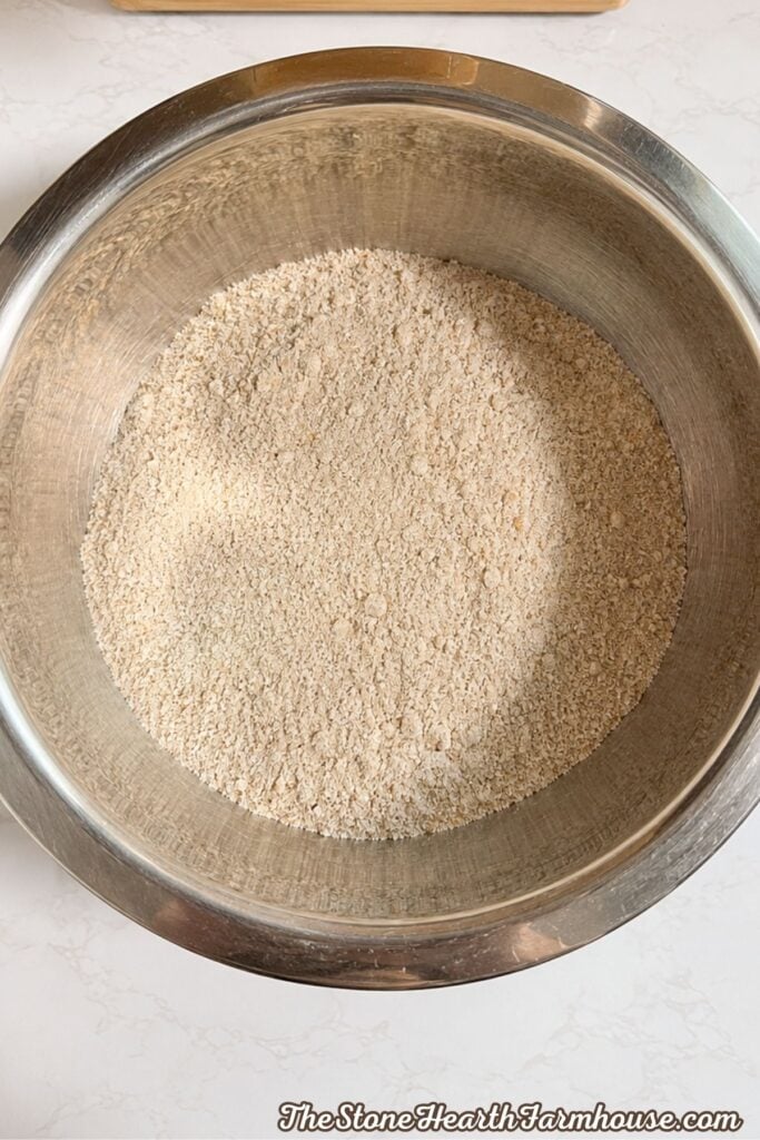 Freshly milled soft white wheat flour in a stainless steel mixing bowl for pumpkin bread