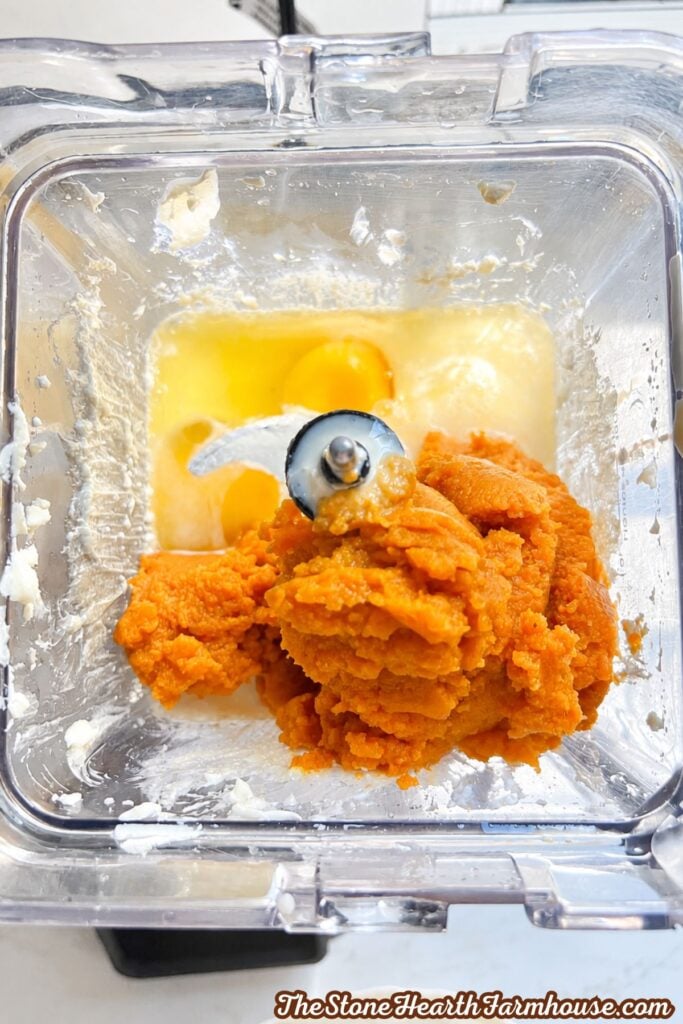 Pumpkin puree and eggs added to the creamy mixture in a blender