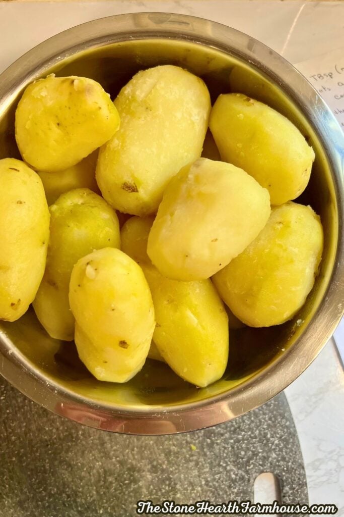 cooked and peeled potatoes in a colander.