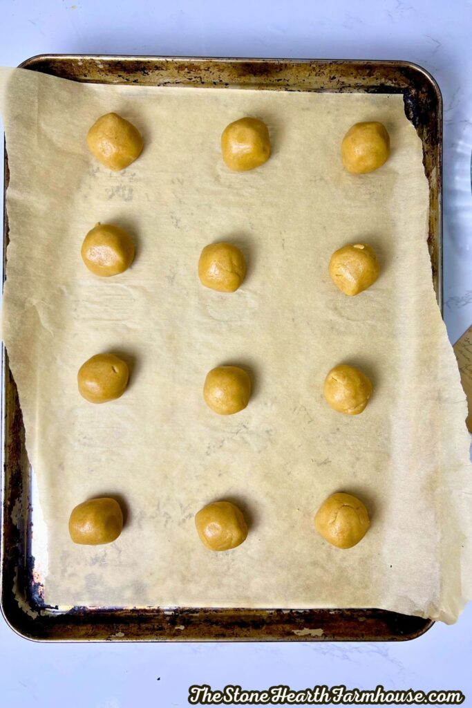 Cookie dough rolled into balls and set on a tray.