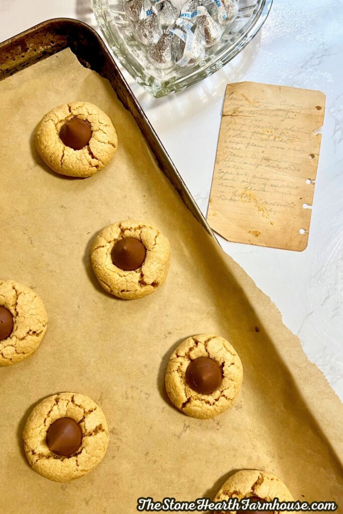 a tray of blossom cookies next to the old recipe card.