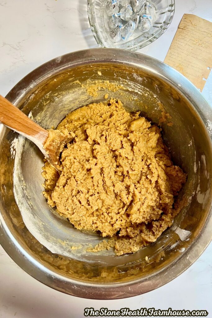 wet and dry ingredients mixed together in a bowl to make peanut butter blossom batters.